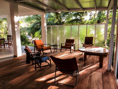 un patio con sillas y mesas en una terraza en Hotel Heliconia Panamá, en Malena