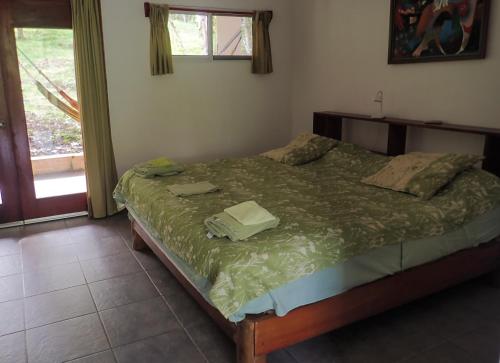 a bedroom with a bed with a green comforter at Hotel Heliconia Panamá in Malena