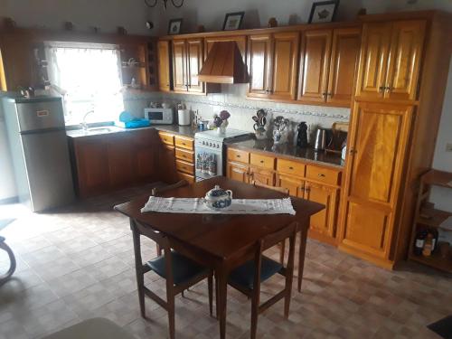 a kitchen with wooden cabinets and a wooden table and a sink at Casa da Matilde in Fajã de São João