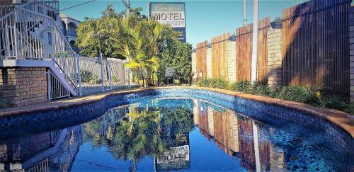una piscina con reflejo en el agua en Limassol Motel, en Gold Coast