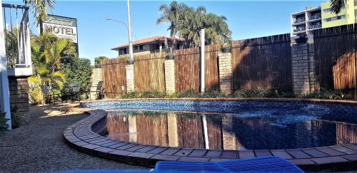 a pool of water in front of a fence at Limassol Motel in Gold Coast