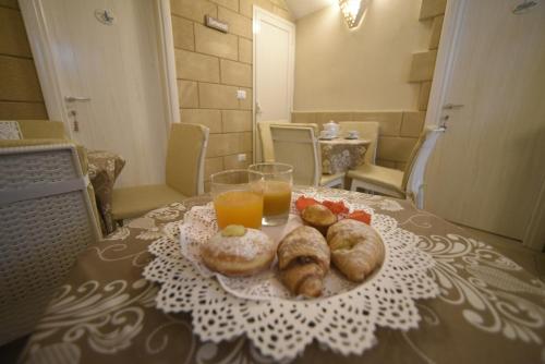 stół z talerzem jedzenia i dwiema szklankami soku pomarańczowego w obiekcie B&B Corte Cantalupi w mieście Gallipoli