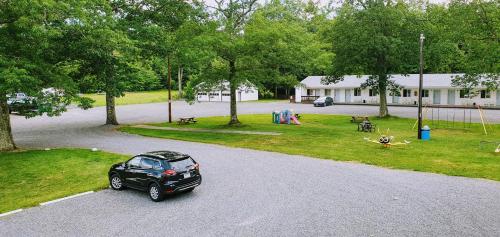 a car parked in a parking lot next to a park at Red Ranch Inn in Catskill