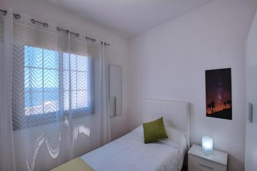 a white bedroom with a bed and a window at La Terraza de Juana in Santa Cruz de la Palma