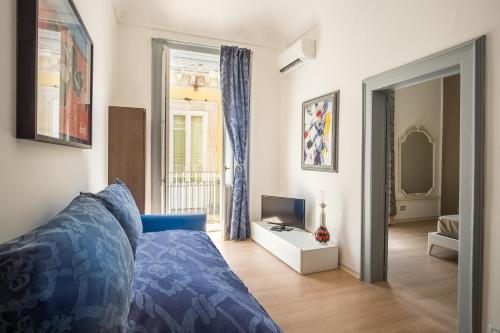 een slaapkamer met een blauw bed en een televisie bij Art House in Siracusa