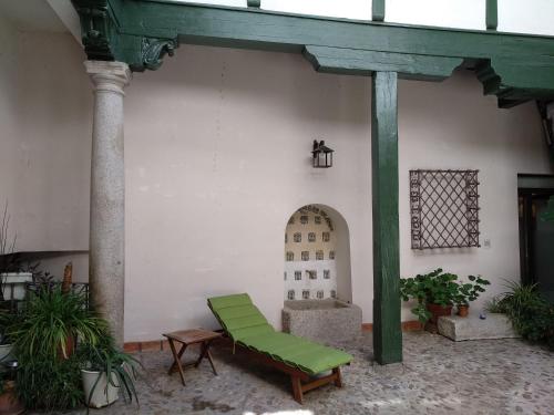 una silla verde sentada en medio de un edificio en El Patio del Convento, en Toledo