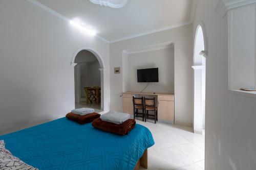 a bedroom with a blue bed with two pillows at Apartamentos Primavera in Jardin