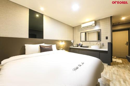 a bedroom with a large bed and a bathroom at Ace Hotel in Tongyeong