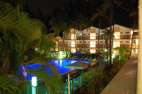 a hotel with a swimming pool in front of a building at Studio Carayou in Les Trois-Îlets