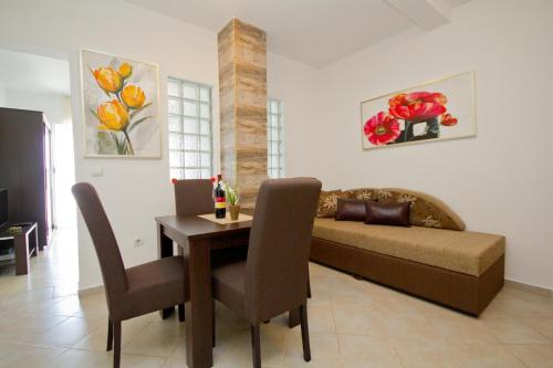 a living room with a table and a couch at Apartments Dora in Dobra Voda