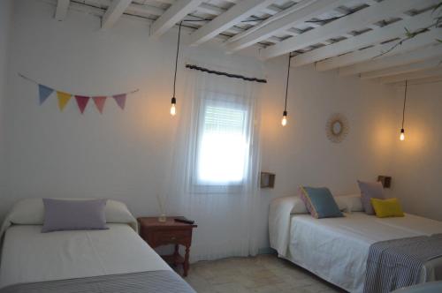 a bedroom with two beds and a window at PENSION SOCAIRE CONIL in Conil de la Frontera