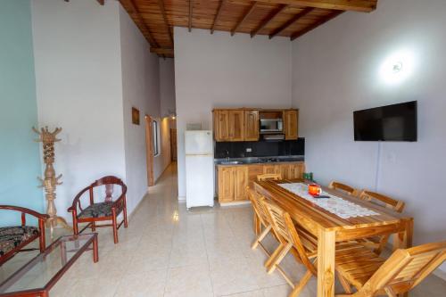 a kitchen with a wooden table and chairs and a refrigerator at Apartamentos Primavera in Jardin