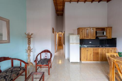 a kitchen with wooden cabinets and a white refrigerator at Apartamentos Primavera in Jardin
