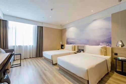 ShangraoにあるAtour Hotel Shangrao Central Squareのベッド2台とソファが備わるホテルルームです。