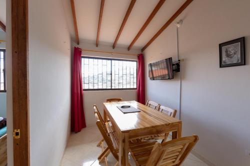a dining room with a wooden table and chairs at Apartamentos Primavera in Jardin