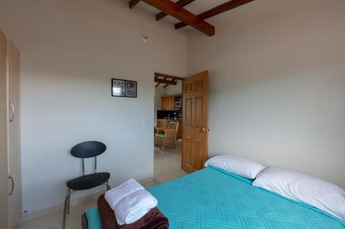 a bedroom with a bed and a chair in it at Apartamentos Primavera in Jardin