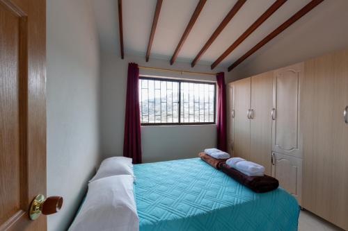 a small bedroom with a bed and a window at Apartamentos Primavera in Jardin