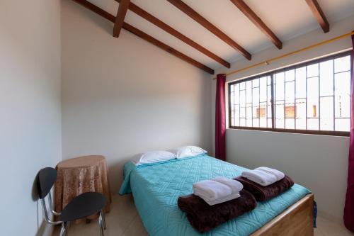 a bedroom with a bed and a window with towels at Apartamentos Primavera in Jardin