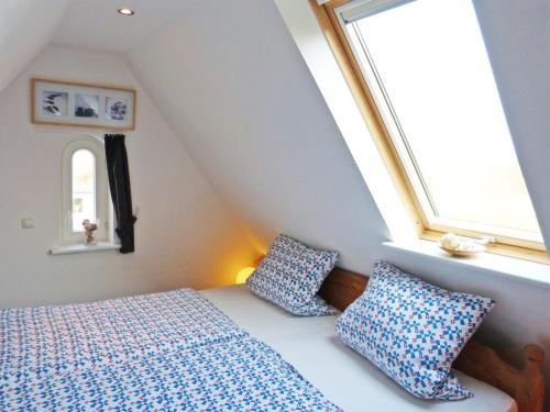 1 dormitorio con cama y ventana en Ferienwohnung *Hüs Pelle*, en Süddorf