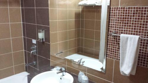 a bathroom with a sink and a shower with a mirror at RHR Hotel Kajang in Kajang