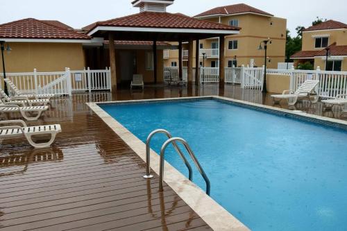 a swimming pool with chairs and a house at MoBay Las Palmas in Montego Bay