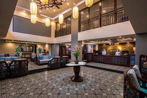 a lobby of a hotel with chairs and a table at Silkotel Hoi An in Hoi An