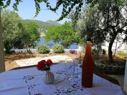 a table with two wine glasses and a vase with flowers at Apartments Boni in Gdinj