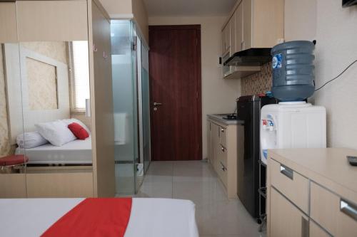 a small room with a kitchen with a refrigerator at RedLiving Apartemen Saladdin Mansion - RAN Management in Depok