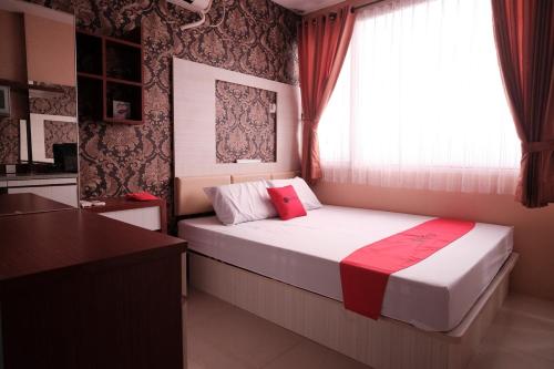 a small bedroom with a bed and a window at RedLiving Apartemen Saladdin Mansion - RAN Management in Depok