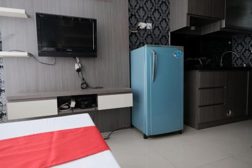 a blue refrigerator in a kitchen with a tv at RedLiving Apartemen Saladdin Mansion - RAN Management in Depok
