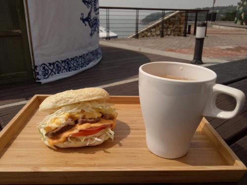- un sandwich sur un plateau à côté d'une tasse de café dans l'établissement Matsu E19, à Nangan