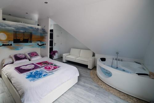 a bedroom with a large bed and a bath tub at La Plumeria in Baincthun