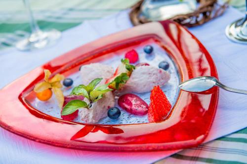 a red plate of food with strawberries and blueberries at Kollerwirt in Kapfenstein