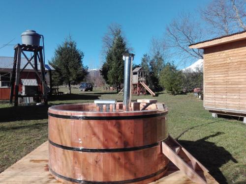 a wooden barrel with a pipe in a yard at Cabañas Captren Andino in Curacautín