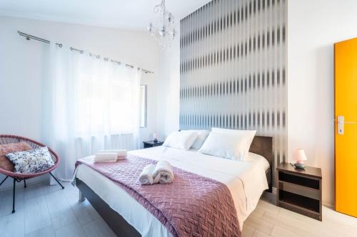 a bedroom with a large bed and a chair at Apartman Debora sa privatnim bazenom in Pula