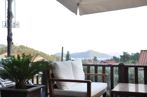 a porch with a chair and a table and a view at Alya Hotel Göcek in Göcek