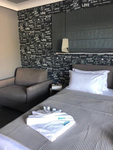 a bedroom with a bed and a couch and writing on the wall at Barocco Wave Hotel in Skala Potamias