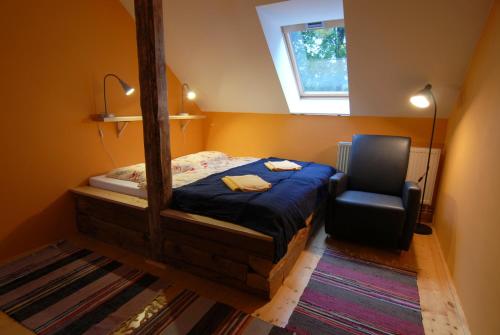 a bedroom with a bed and a mirror and a chair at Penzion Dvůr in Obora