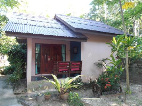 a small house with red chairs in front of it at Aonang Green Park Bungalow in Ao Nang Beach