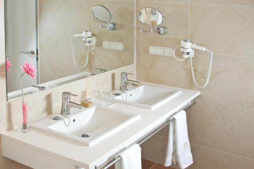 a bathroom with a white sink and a mirror at Hotel Rural Binigaus Vell in Es Migjorn Gran
