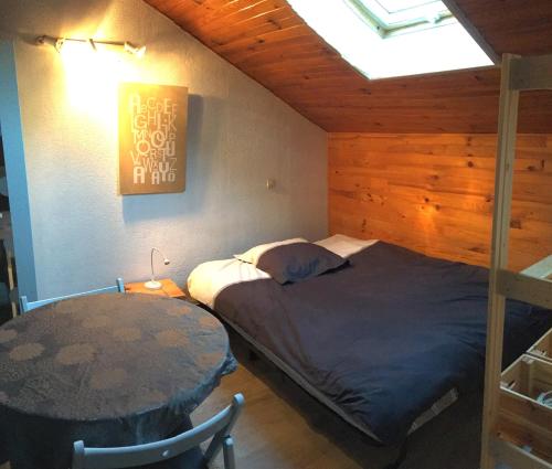 a bedroom with a bed and a table in it at Studio Alphabet in Chambéry