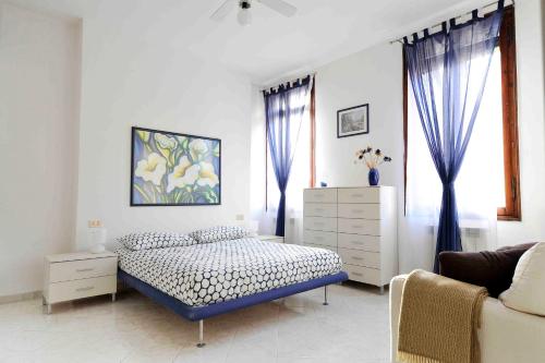 a white bedroom with a bed and a window at SantaMarta, the apartment for your Venetian holidays in Venice
