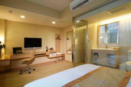 um quarto com uma cama e uma secretária com uma televisão em Hotel Color em Taipei