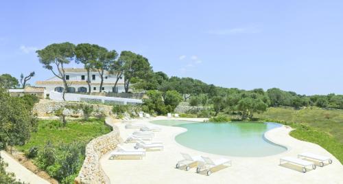 an aerial view of a resort pool with lounge chairs at Hotel Rural Binigaus Vell in Es Migjorn Gran