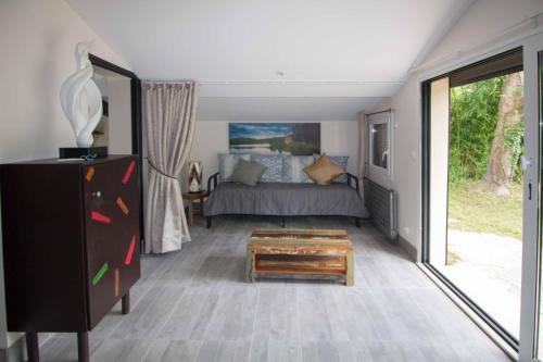 a bedroom with a bed and a large sliding glass door at La Ravine au bord du loing in Montigny-sur-Loing