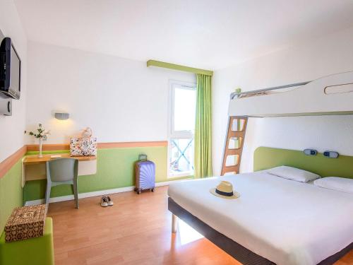um quarto com uma cama, uma secretária e um beliche em ibis budget Cannes Mougins em Mougins