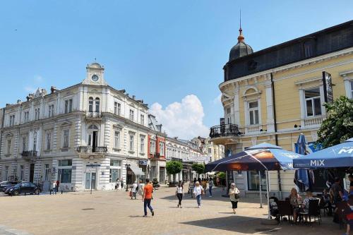 a group of people walking on a street with buildings at Sky Blue Danube Apartment Ruse in Ruse