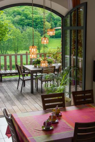 un patio avec une table et des chaises sur une terrasse dans l'établissement La Haute Forge B&B, à Thoiré-sur-Dinan