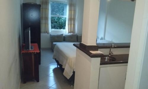 a hotel room with a bed and a sink at Vários Flats no CAVALINHO BRANCO com PISCINA COBERTA E AQUECIDA in Águas de Lindóia