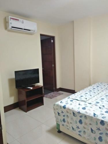 a bedroom with a bed and a flat screen tv at Lourdes Inn in Manila